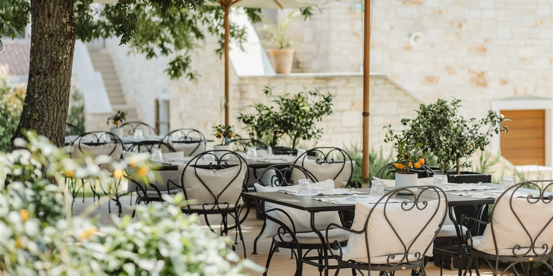 Tables set at Oliveto, the outdoor dining terrace at Meneghetti