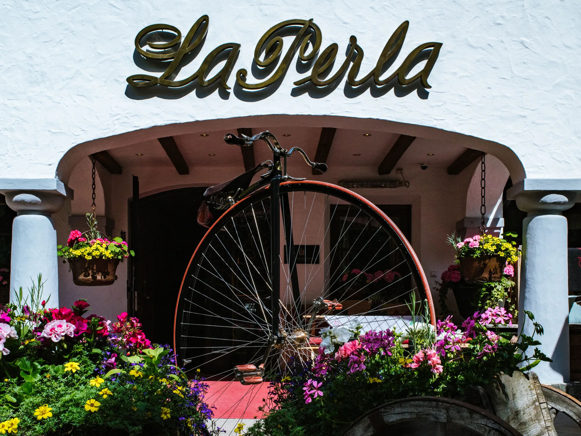 Hotel La Perla in Corvara, Alta Badia: the hotel entrance with the gold La Perla sign