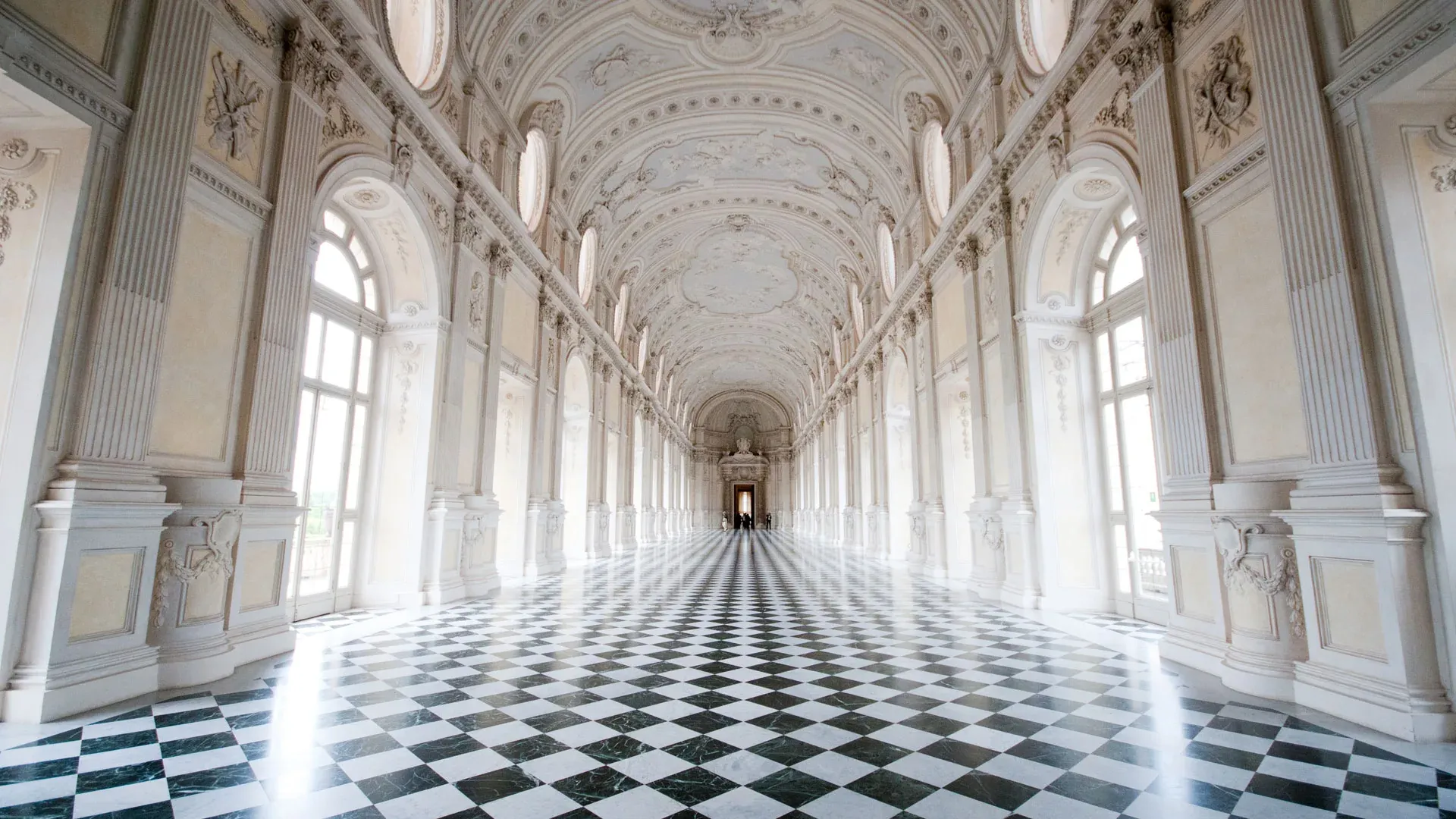 The Great Gallery at the Reggia di Venaria, a long hall with a chequered marble floor and tall windows.